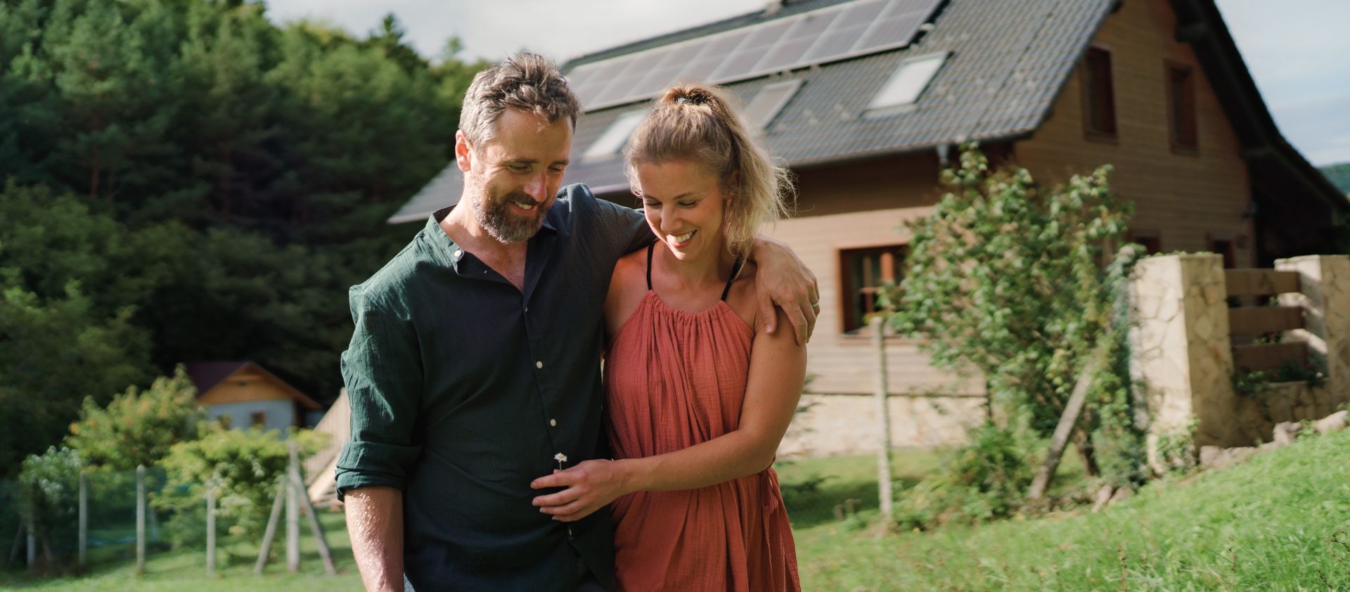 Glückliches Paar vor Haus in Norderstedt mit Photovoltaik