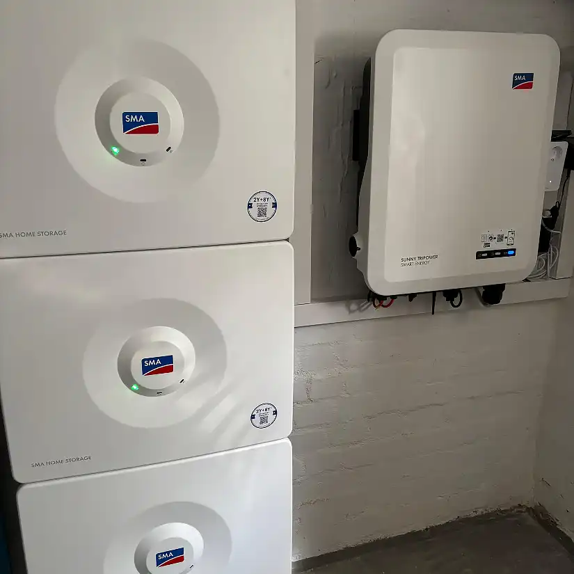 Drei SMA Batteriespeicher an der Wand neben einer Wallbox