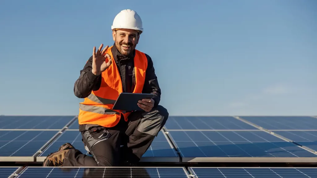 PV-Installateur auf einem Hausdach mit einer Photovoltaikanlage