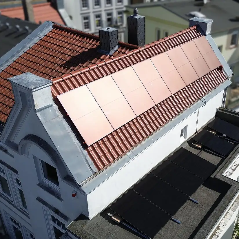 Rote Solarmodule auf einem denkmalgeschützten Dach