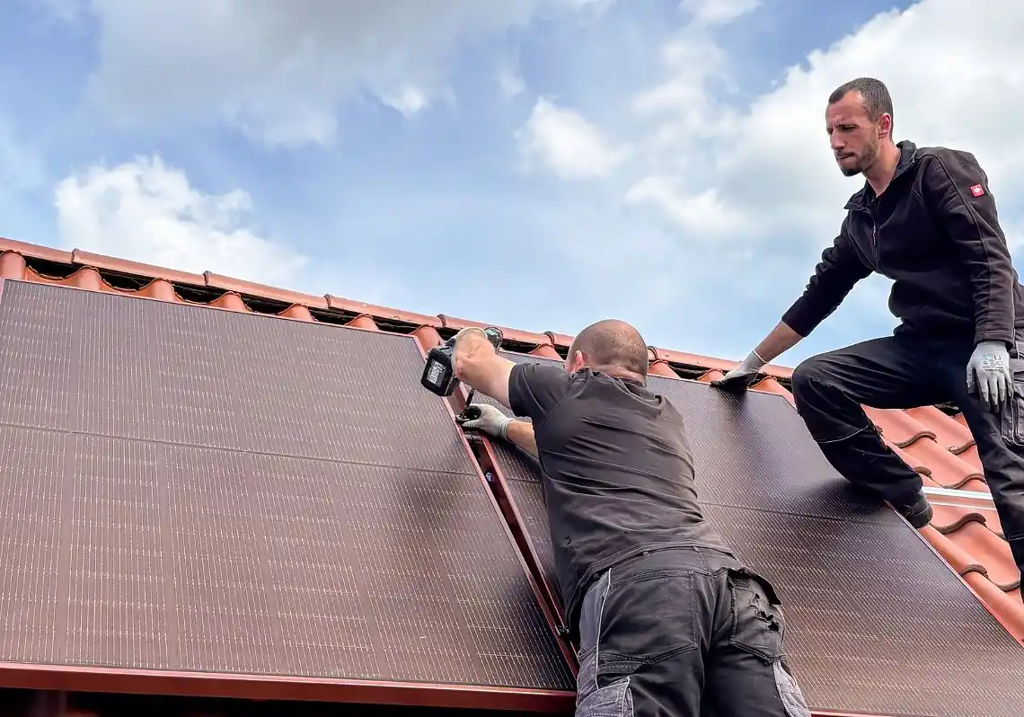 Zwei Monteure bei der Installation einer PV-Anlage